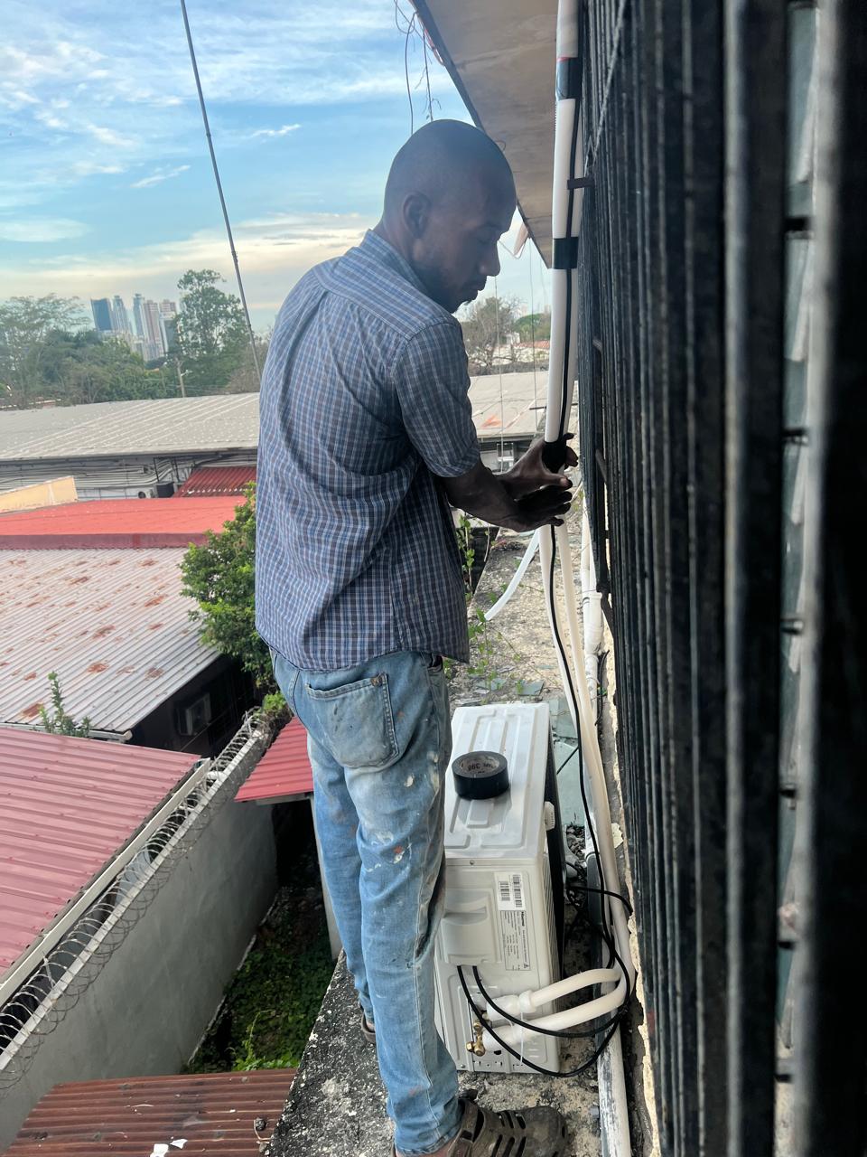 Técnico instalando aire acondicionado en altura, Ciudad de Panamá